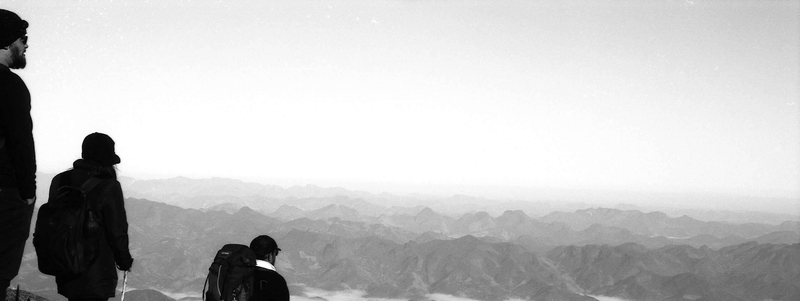 Three hikers on a mountainside, black and white photo